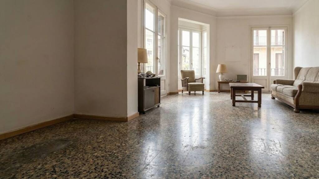 Retiramos un viejo terrazo frío para instalar un suelo laminado de gran formato que ha multiplicado la luz natural de este salón sin necesidad de picar el suelo existente.